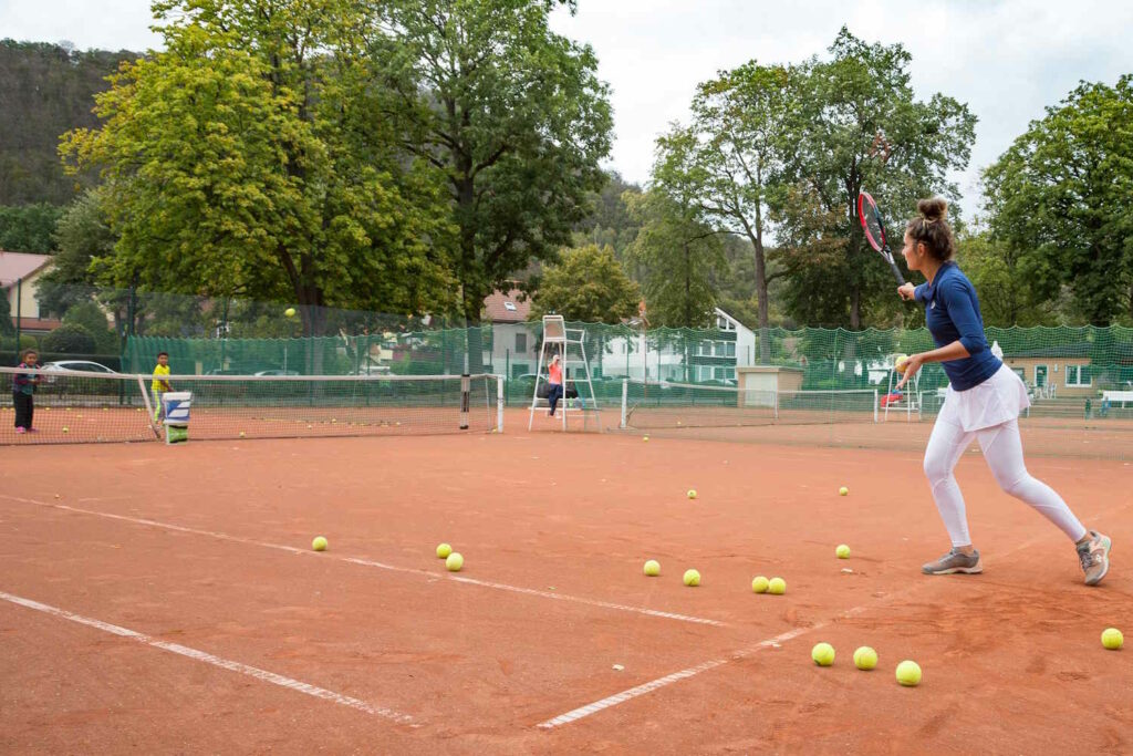 Frau spielt mit Kindern Tennis