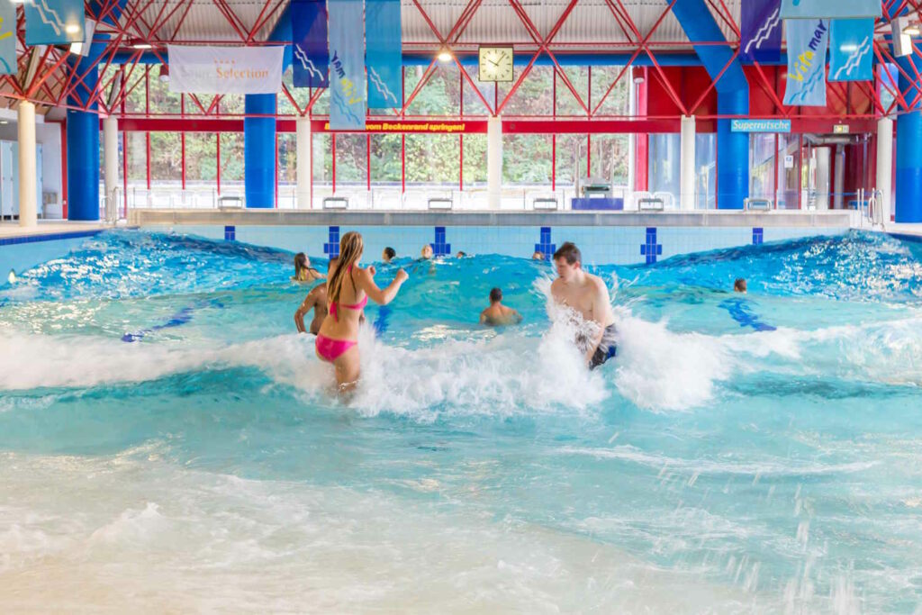 Paar springt in die Wellen im Wellenbecken im Vitamar