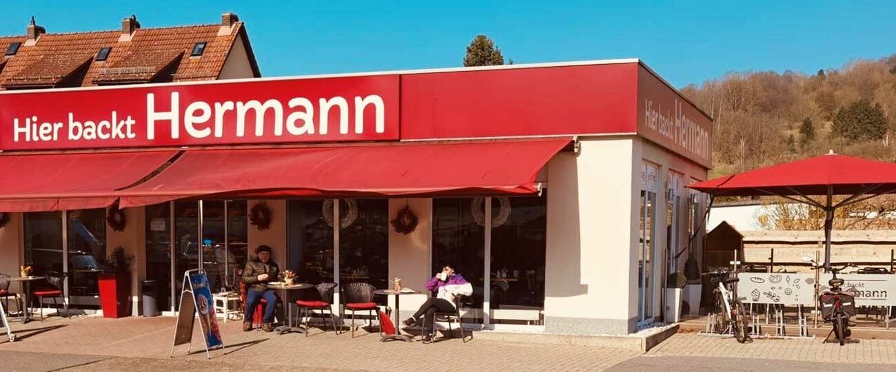 Außenansicht mit einigen Sitzplätzen der Bäckerei Herrmann